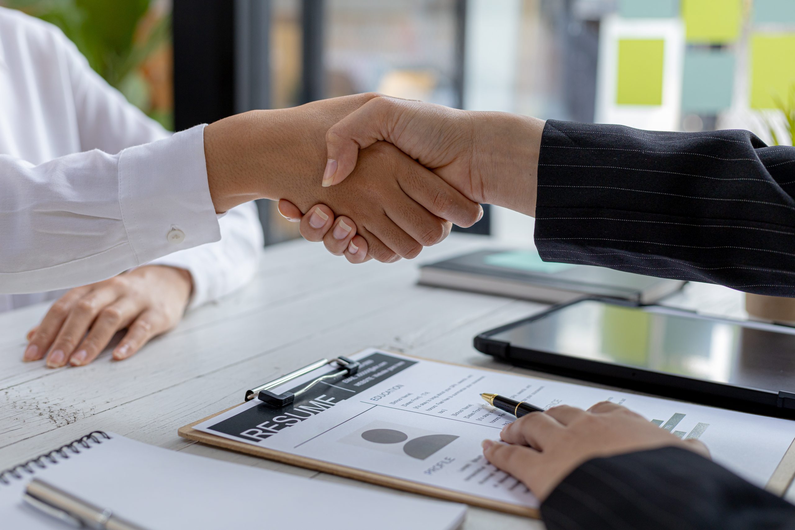 The job interviewer and the job applicant are holding hands after the job interview is finished. The concept of recruiting employees to work in the company, vacant positions.