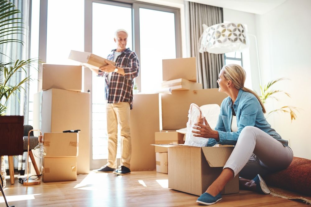 Real Estate, Property and a Senior Couple Moving House While Packing Boxes Together in Their Home. Box, Investment and Retirement with Old People Unpacking in the Living Room of Their New Apartment